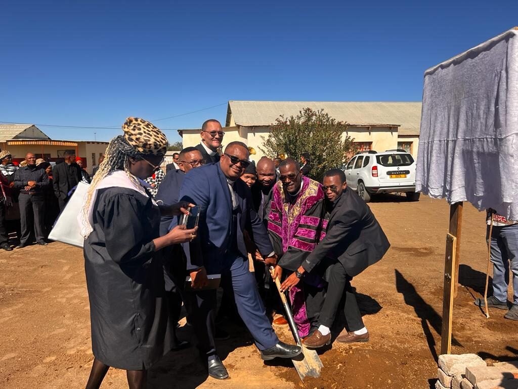 Bishop Silvester Beaman (purple robe) poses for a photo with congregants