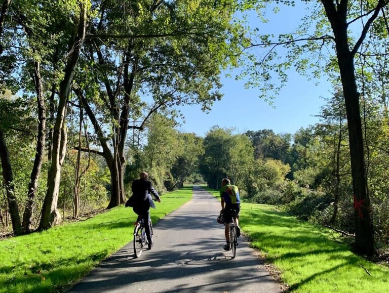 Two cyclists are seen on the Commons Boulevard Pathway Bike Trail