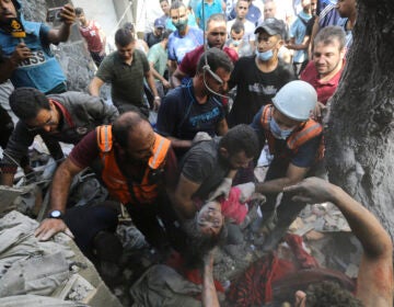 Palestinians rescue a child from under the rubble after Israeli airstrikes in Gaza City