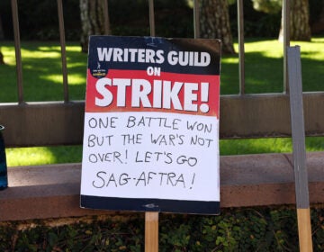 A WGA support sign rests near SAG-AFTRA members picketing outside Warner Bros. Studio as the actors strike continues on September 26, 2023 in Burbank, California. (Mario Tama/Getty Images)