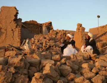 Afghan residents sit at a damaged house after an earthquake in a village in Herat province on Saturday.