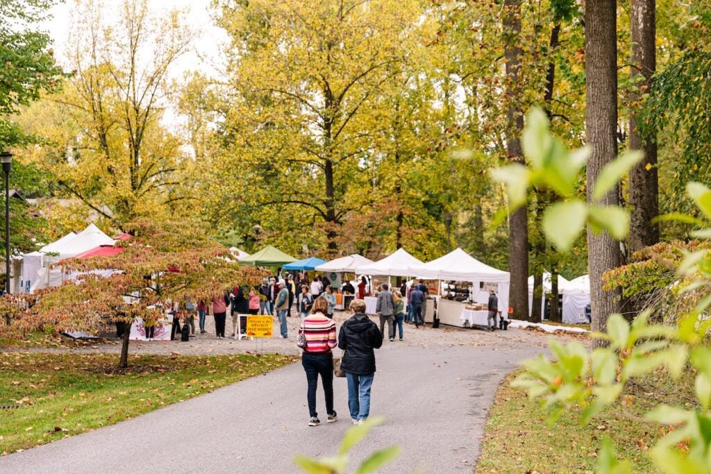 People stroll down a pathway near where vendors are set up