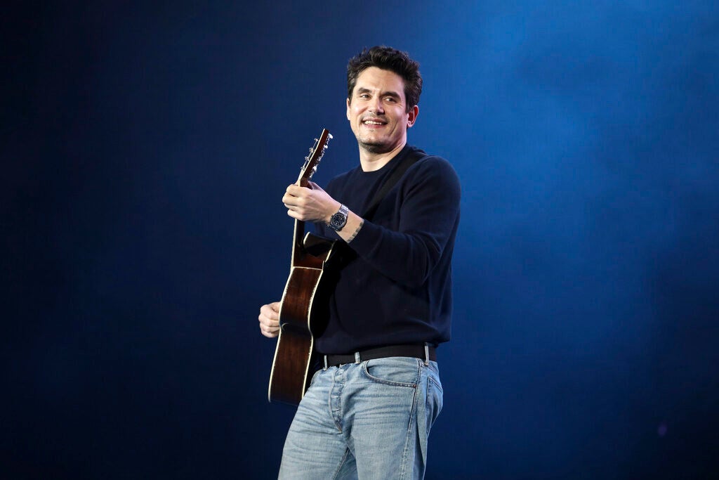 John Mayer playing a guitar onstage