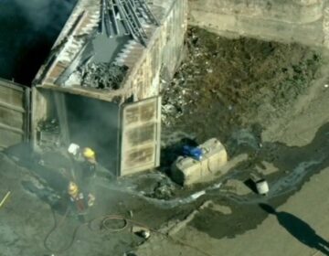 An aerial view of firefighters hosing down the site of an explosion in Roxborough