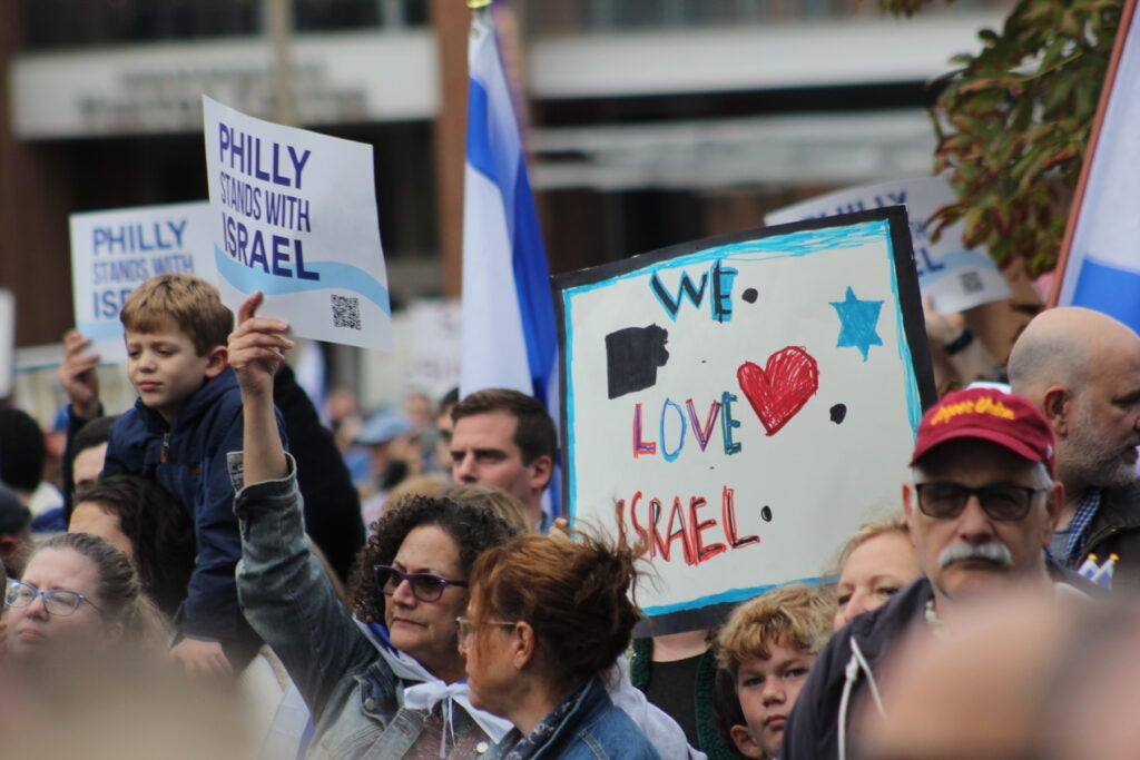 People at the Pro-Israel rally holding up signs.