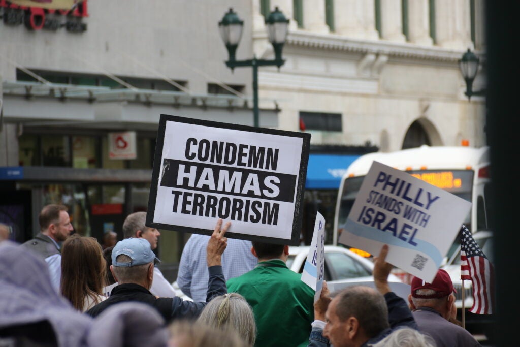 A sign says ''Condemn Hamas terrorism' against the backdrop of a march for Israel