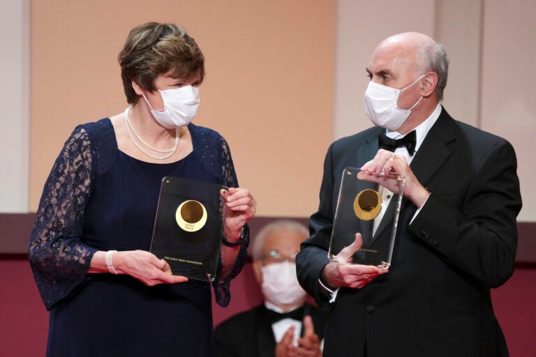 Katalin Kariko, left, and Drew Weissman, pose with trophies