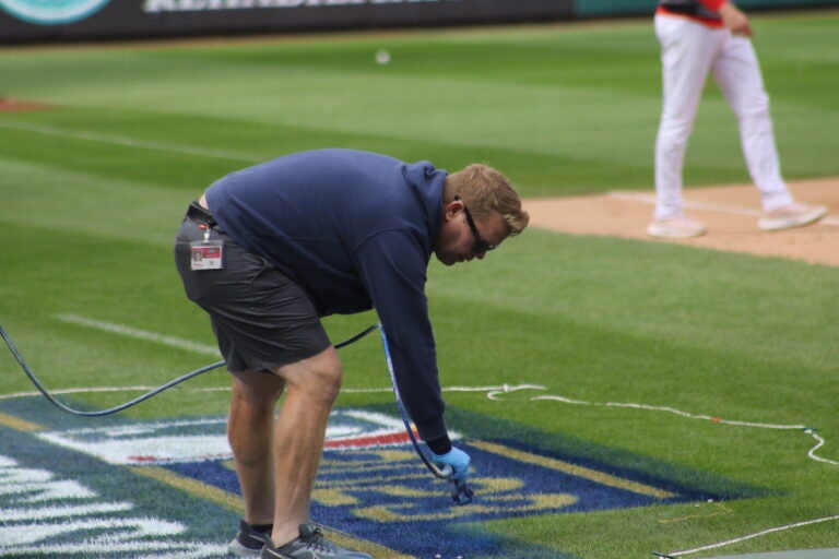 A stadium worker paints the field at Citizens Bank Park