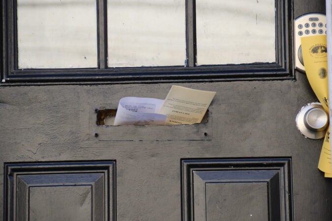 A flyer sticking out of a mail slot is visible.