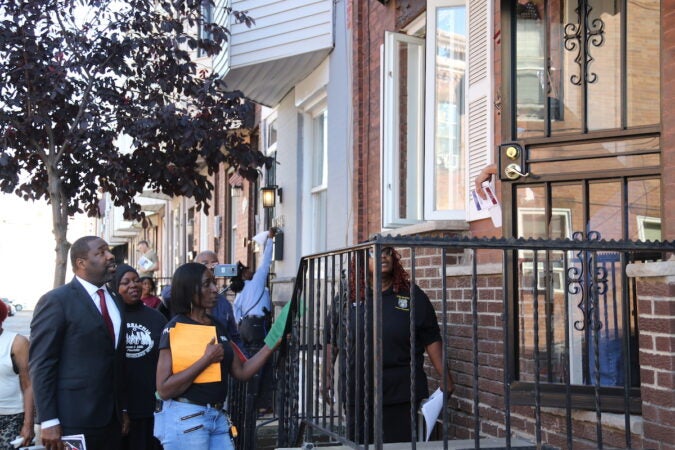 Councilmember Kenyatta Johnson (left) speaks with a resident while delivering information on trauma support services Wednesday.