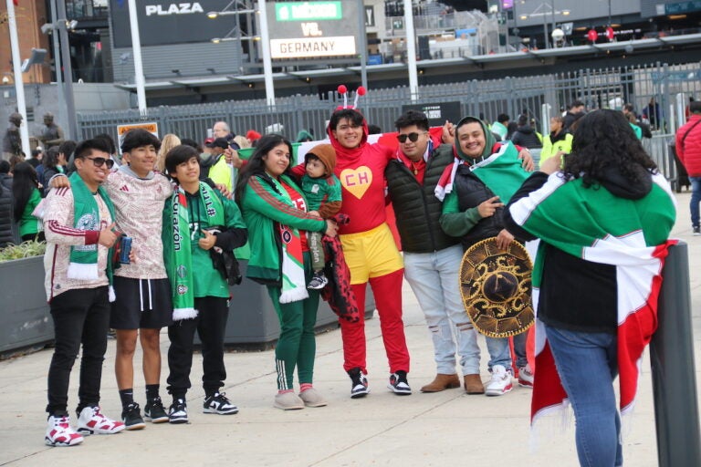 Fans wearing Mexico's national soccer team gear pose for a photo.