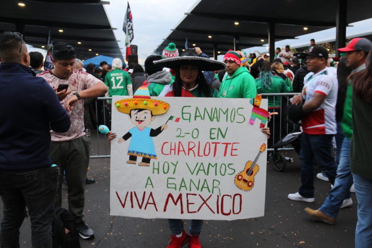 A fan holds a sign that reads 