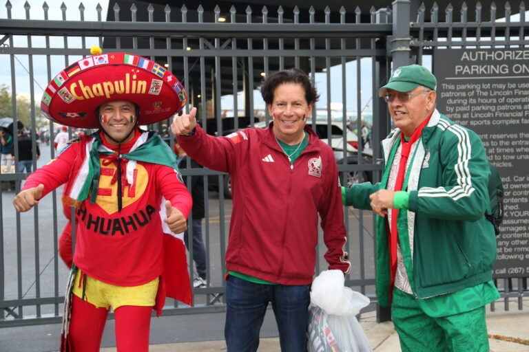 Three fans of Mexico's national soccer team pose for a photo