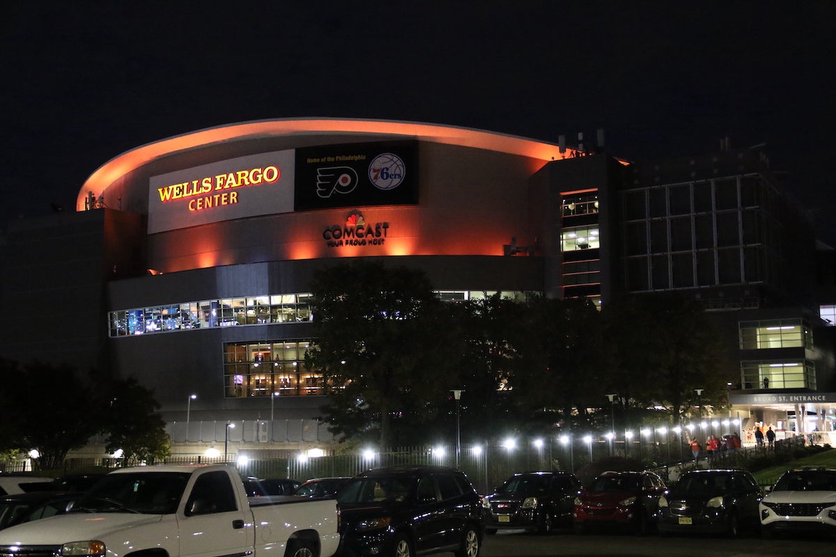 The exterior of the Wells Fargo center lit up with orange lights