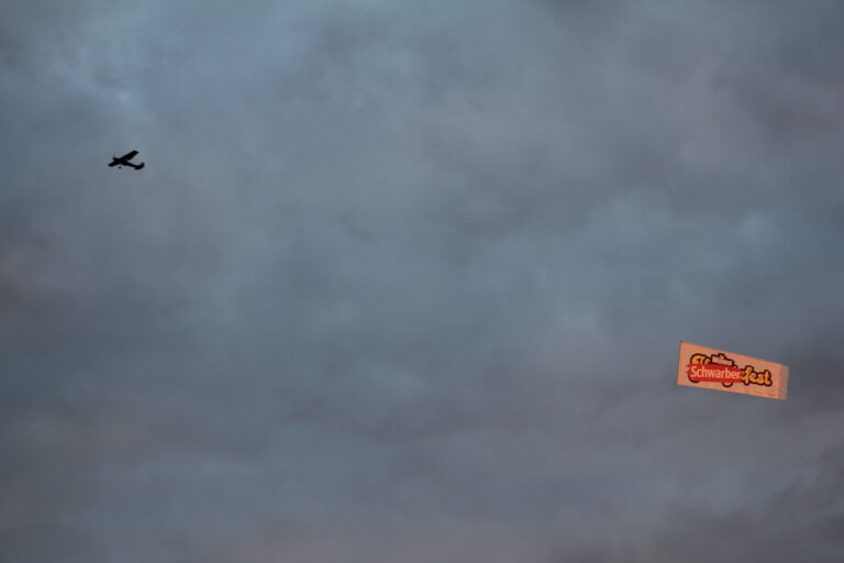 A plane flies a banner that reads 