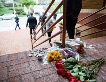 flowers and candles on the steps of the building.