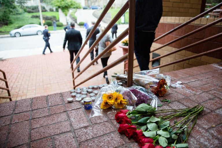 flowers and candles on the steps of the building.