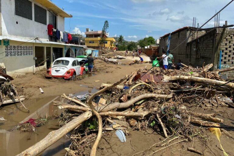 Downed trees and rubble are visible on a street in Acapulco