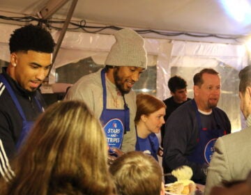 Members of the Philadelphia 76ers served meals to military service members and veterans onboard the Battleship New Jersey on Monday. (Cory Sharber/WHYY)