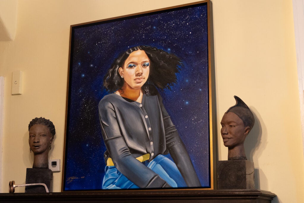 A portrait of Myka and sculptures displayed on the wall.