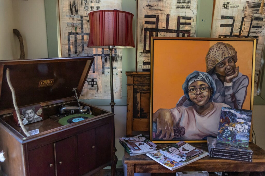 A painting of two Black women is displayed next to a record player