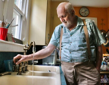 Douglas Frost turns on the tap in his Salem, N.J., home.