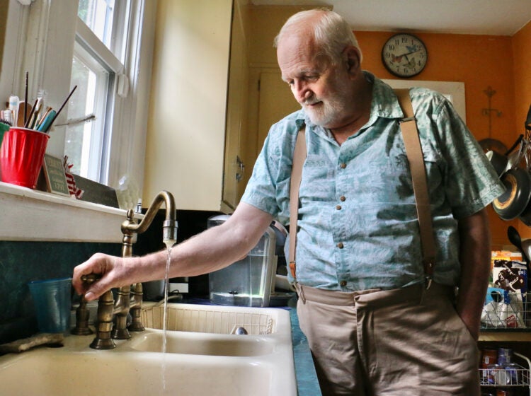 Douglas Frost turns on the tap in his Salem, N.J., home.