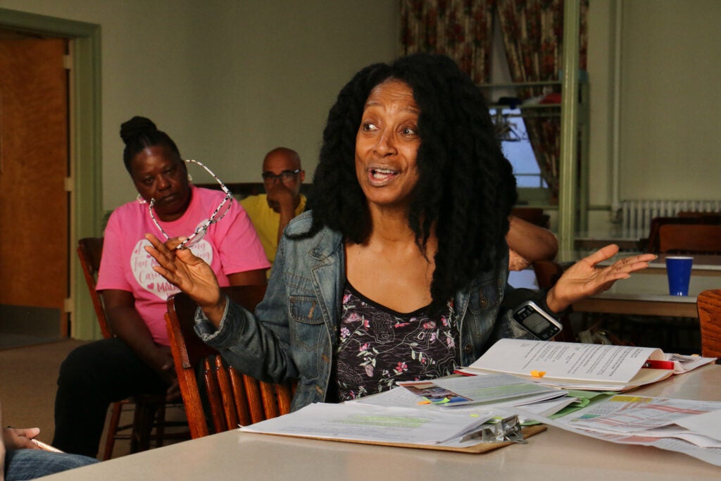 Janice Roots raises her hands as she speaks