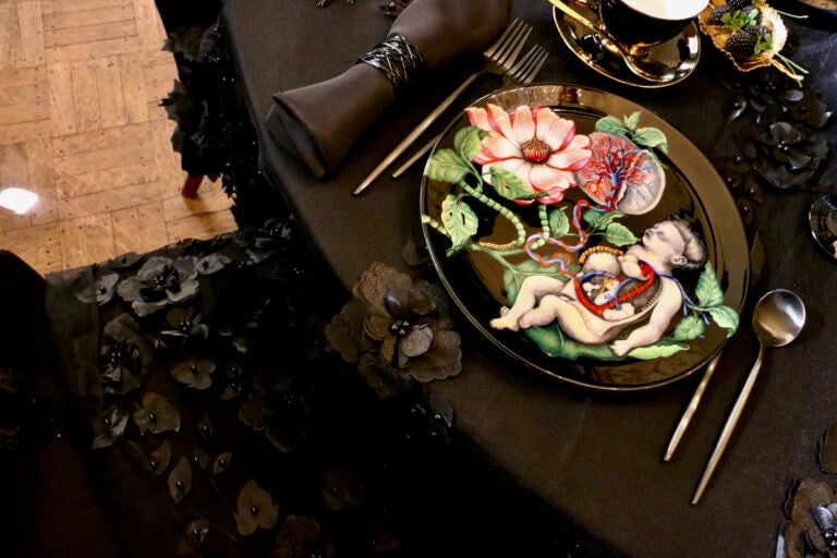 A plate showing a child is set on a black lace table cloth