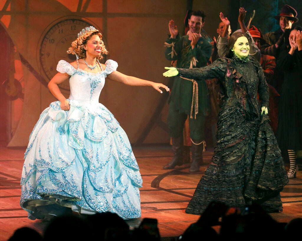 Actors Brittney Johnson, left, and Lindsay Pearce appear on stage during the curtain call of the musical "Wicked" at the Gershwin Theatre