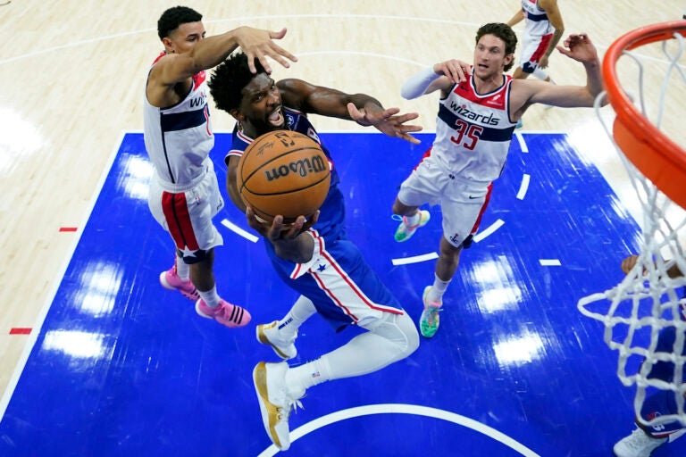 Philadelphia 76ers' Joel Embiid (center) goes up for a shot against Washington Wizards' Johnny Davis, left, and Mike Muscala during the second half of an NBA basketball game, Monday, Nov. 6, 2023, in Philadelphia. (AP Photo/Matt Slocum)