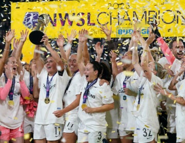 NJ/NY Gotham defender Ali Krieger holds the trophy after NJ/NY Gotham defeated OL Reign 2-1 in the NWSL Championship soccer game, Saturday, Nov. 11, 2023, in San Diego.