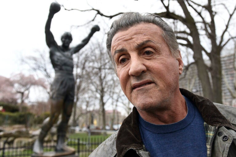 Sylvester Stallone in front of his statue