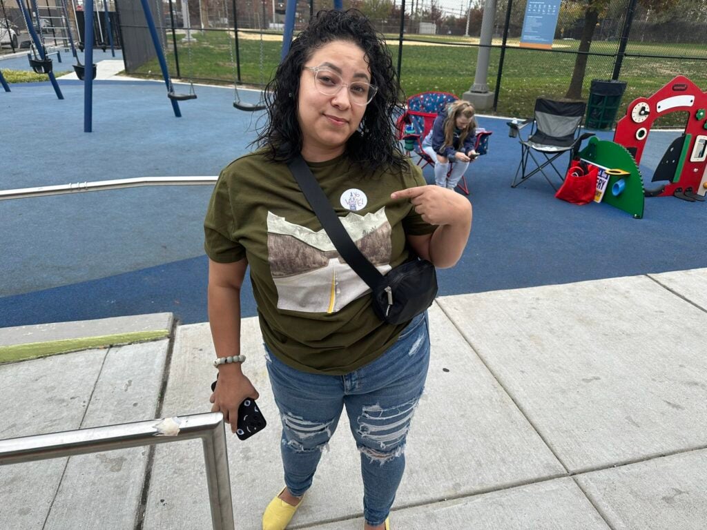 A voter points to an ''I voted'' sticker outside their polling station