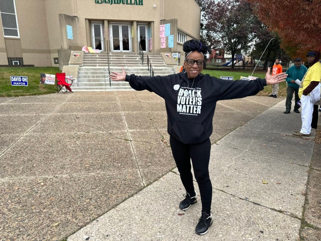 A voter outstretches their arms in front of their polling station