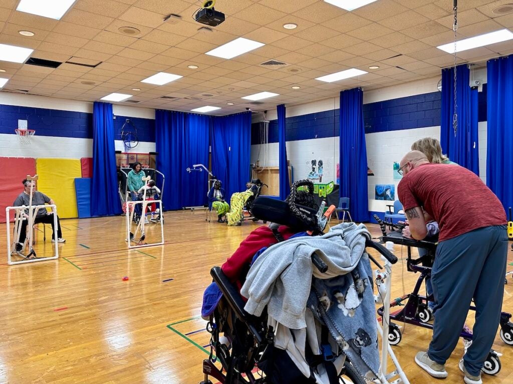 Children playing with adaptive play equipment in a gym