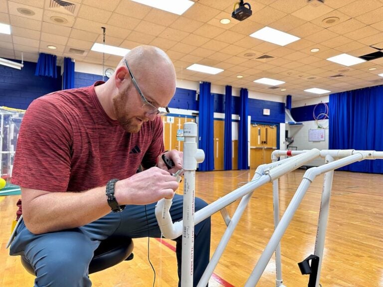 Frank Hughes fixes a piece of adaptive play equipment