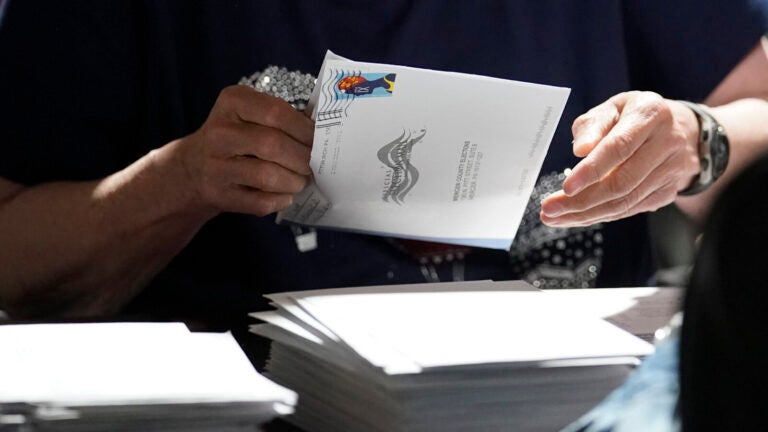 An election worker continues the process of counting ballots for the 2022 Pennsylvania primary election in Mercer, Pa.