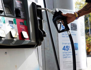 A customer replaces the pump dispenser at a Chevron gas station in Columbus, Miss., on Oct. 23. The average price of regular gas has fallen more than 40 cents from a year ago.