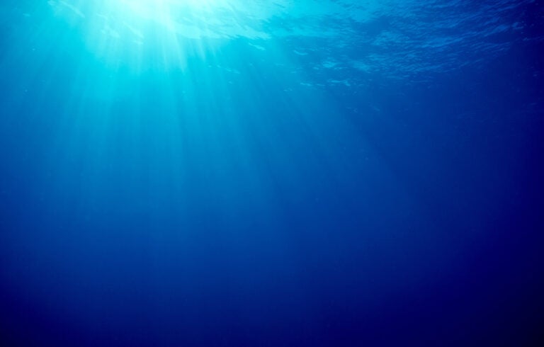 Underwater blue background in ocean with sunbeams Stock Photo