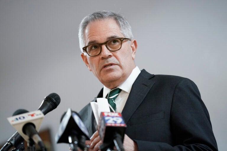 Krasner speaks into microphones at a press conference