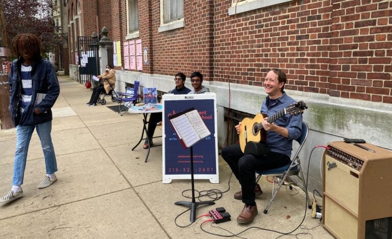 Nero Catalano plays his guitar outside a polling place