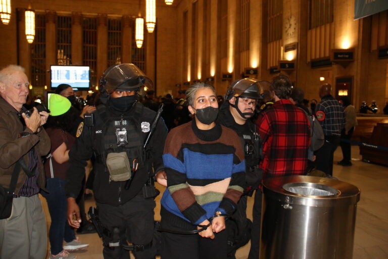 A protester is led away with hands tied by police