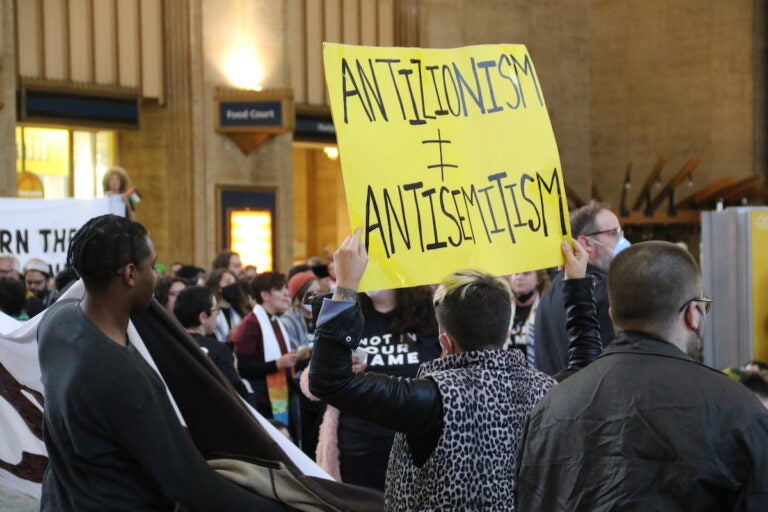 A person holds up a sign that reads 