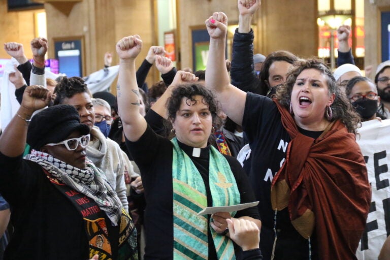 Protesters raise their fists together.