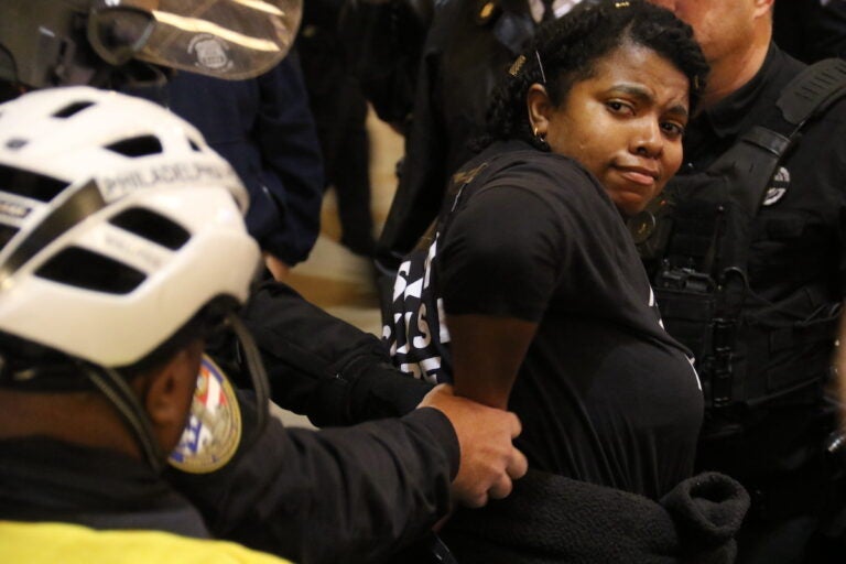 A protester is detained by police