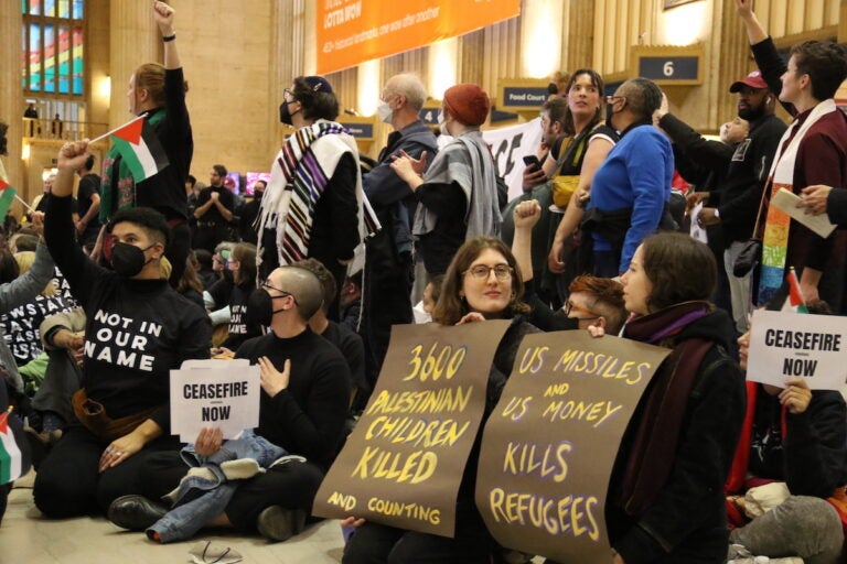 Protesters hold signs that read 