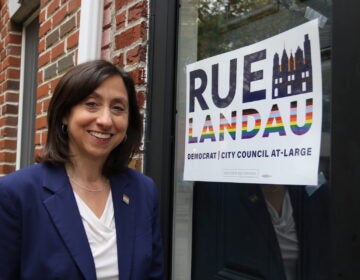 Rue Landau posing in front of her campaign sign.