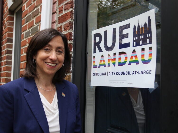 Rue Landau posing in front of her campaign sign.