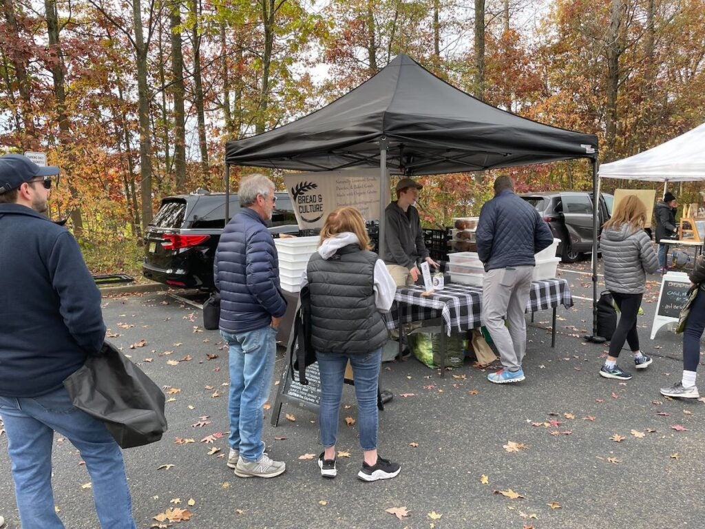 People stand in a line at a farmers market